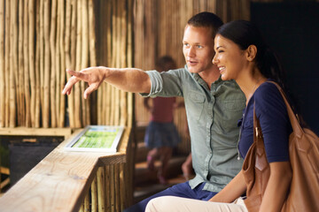 Happy couple, pointing and date at aquarium with tourist for sightseeing, travel or tour at the...