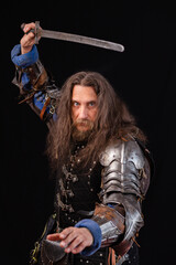 Portrait of a medieval knight with a characteristic historical appearance with a sword. ESports. Vertical composition.