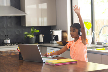 Biracial girl engaged in online learning at home