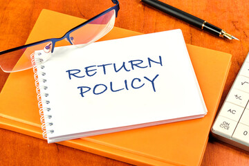 Return Policy written on a clean white notebook