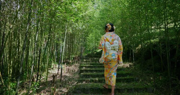 Asian woman wear Japanese kimono in the bamboo forest