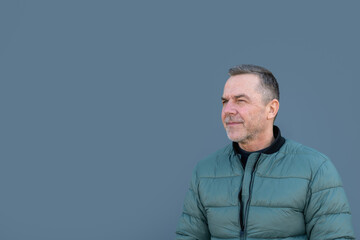 Upper body portrait of a middle aged man looking sideways with a critical look