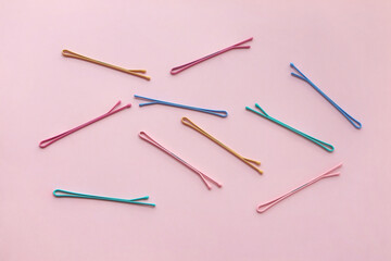 Top view of colorful pastel color hair clips on pink background. modern accessories for hair, accessories and hairstyles concept, luxury color