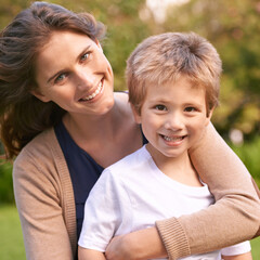 Fototapeta premium Mother, son and hug with park, love and smile with portrait and together for happiness. Woman, child and nature with embrace, bonding and family with care and childhood for parenting in backyard