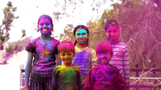 Happy Cute Indian kids applying colours on each other on the occasion of colors festival holi