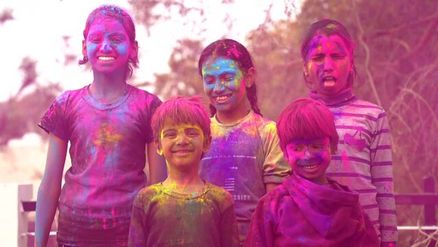 Happy Cute Indian kids applying colours on each other on the occasion of colors festival holi