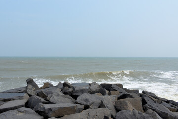 Fototapeta na wymiar Waves crashing on rocks on beach.