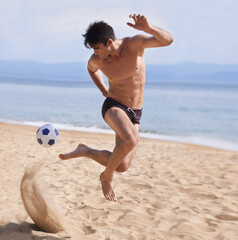 Male athlete, soccer and sand on beach, exercise and training for cardio sports. Bathing suit, football and athletic man on holiday and fun on shoreline, summer and workout and outdoor on vacation
