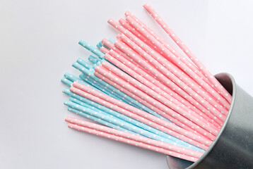 Pink polka dot paper straws and light blue polka dot paper straws on white background. Drinking straws, Eco friendly paper straws concept.