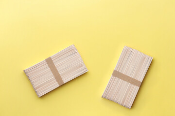 Wooden popsicle sticks on yellow background. Ice cream wooden sticks,Ice lolly sticks.DIY Concept