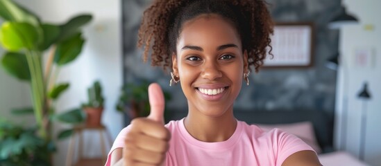 Portrait of a happy young woman showing thumbs up gesture of approval and success