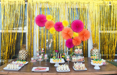 Dessert Table with Pineapple Decorations on a Wooden Table
