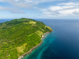 Fototapeta na wymiar Cobrador Island with green trees and turquoise water in coastline. Romblon, Philippines.