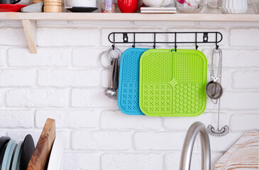washed pet lick mats handing above kitchen sink