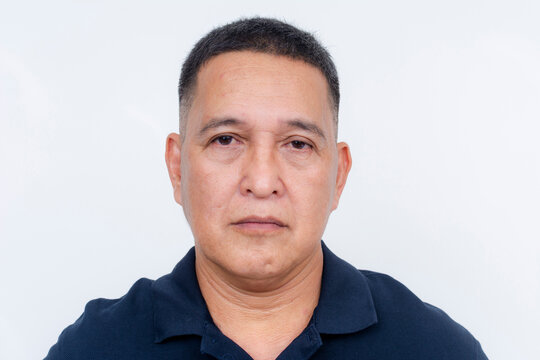 Stoic and serious expression of a middle-aged Asian man, isolated on a clean white backdrop.