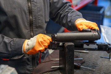 Assembling firearms by a factory worker in the workshop.