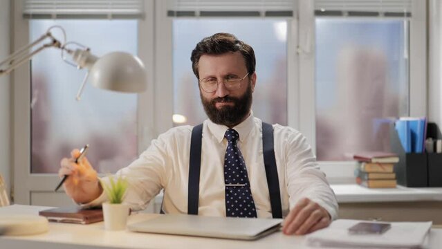 Successful man, businessman, big boss concept. Portrait of man who looks like lawyer or bank employee, professional sits at desk and looks confidently and proudly looking at camera. Worker in office