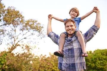 Smile, nature and child on father shoulders in outdoor park or field for playing together. Happy, bonding and portrait of excited young dad carrying boy kid for fun in garden in Canada for summer.