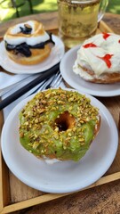 close up of green matcha glazed donut in white plate on coffee shop