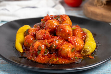 Aleppo meatballs. Appetizer dishes. Small meatballs with tomato paste on a blue wooden background. Close up