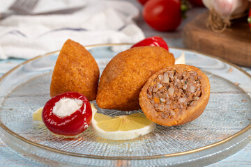 Stuffed meatballs. Appetizer dishes. Kibbeh on blue wooden background. local name içli köfte. Close up