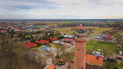 A drone captures Gąski beach, West Pomeranian Voivodeship, Poland, featuring a red brick lighthouse. © Grzegorz