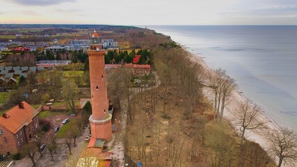 A drone captures Gąski beach, West Pomeranian Voivodeship, Poland, featuring a red brick lighthouse. © Grzegorz