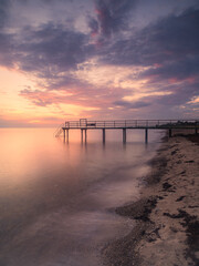 Tranquil Swedish Pier at Sunset With Calm Sea and Colorful Skies