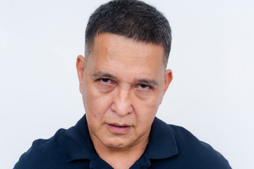 Obraz premium A portrait of an unhappy middle-aged Asian man looking displeased, set against a white background.