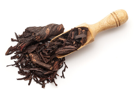 Top view of a wooden scoop filled with Organic Alkanet or Ratan Jot (Alkanna tinctoria) roots. Isolated on a white background.