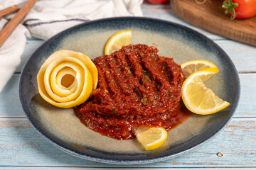 Spicy appetizer. Appetizer dishes. Spicy pate on blue wooden background. local name acılı ezme. Close up