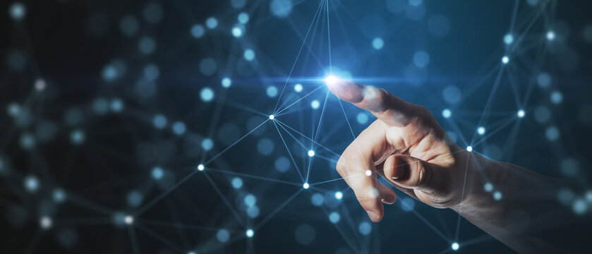 A human hand reaching out to touch a point within a complex network of connections, symbolizing interaction and technological reach