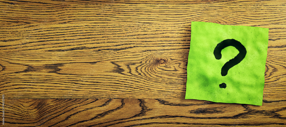 Fototapete close up of green note paper with question mark on wide wooden desktop with mock up place. questions