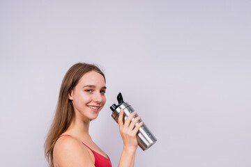 Image of beautiful strong happy cheerful young sports woman posing isolated indoors drinking water.