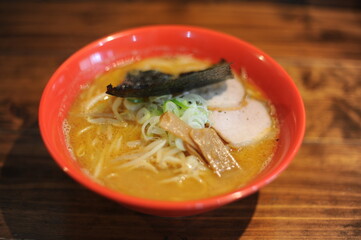 Traditional delicious ramen noodle soup in a bowl cooked with miso paste, meat, seaweed and onion in Japan