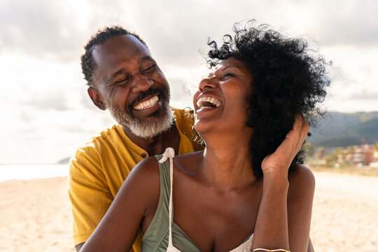 Beautiful mature black couple of lovers dating at the seaside - Married african middle-aged couple bonding and having fun outdoors, concepts about relationship, lifestyle and quality of life