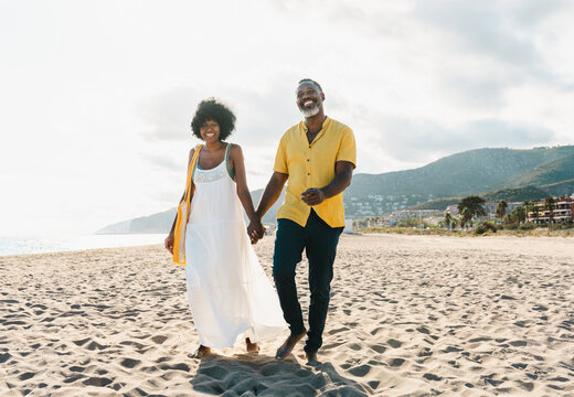 Beautiful mature black couple of lovers dating at the seaside - Married african middle-aged couple bonding and having fun outdoors, concepts about relationship, lifestyle and quality of life