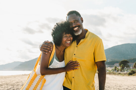Beautiful mature black couple of lovers dating at the seaside - Married african middle-aged couple bonding and having fun outdoors, concepts about relationship, lifestyle and quality of life