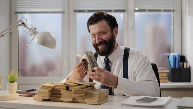 Income, theft, bribe concept. Positive successful businessman, broker or corrupt politician laughs with happiness and counts money, admiring profit. Profitable business or career for office worker