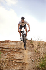 Portrait, bike and man off road cycling on dirt track for sports, competition or outdoor hobby. Fitness, nature and race with confident young athlete or cyclist in helmet for cardio performance
