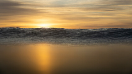 Fototapeta na wymiar Sunrise in ocean with waves breaking