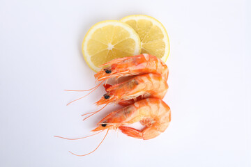 Delicious cooked shrimps and lemon isolated on white, top view