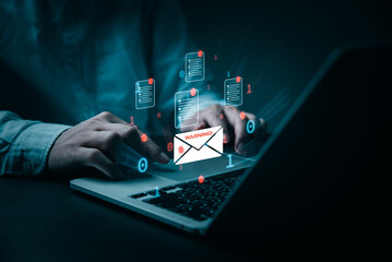 A person's hands are shown typing on a laptop, surrounded by digital email icons of documents and a warning sign. The image conveys a sense of urgency and attention to cybersecurity threats.