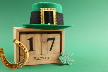 St. Patrick's day - 17th of March. Wooden block calendar, leprechaun hat, golden horseshoe and...