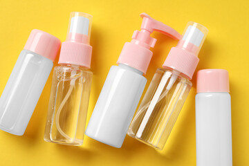 Cosmetic travel kit on yellow background, flat lay. Bath accessories