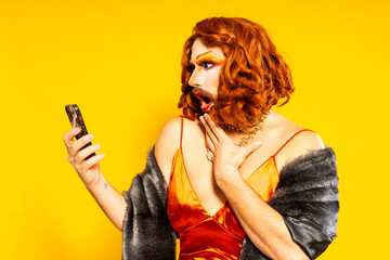 Surprised drag queen standing with smartphone