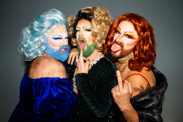 Expressive drag queens in makeup standing in direct flash light - obrazy, fototapety, plakaty