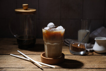 Fototapeta na wymiar Refreshing iced coffee in glass and straws on wooden table