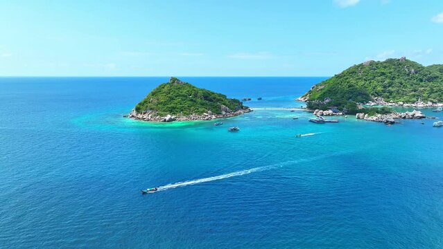 Discover a paradisiacal island oasis, linked by sandy pathways, inviting you to explore vibrant marine life in pristine, azure waters. Aerial drone. Nature stock footage. Gulf of Thailand. 4K HDR.
