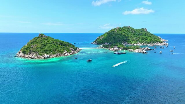 Embark on an aquatic adventure at our sandbar-connected island, where crystalline waters await, beckoning snorkelers and divers alike. Aerial view. Tropical sea background. Tao island, Thailand. 4K. 
